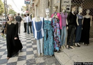 A Palestinian woman walks next to mannequins outside shops in Gaza City July 28, 2010. The Islamist rulers of the Gaza Strip have ordered lingerie shops to display more modesty. A week after banning women from smoking water pipes in public places, the Hamas-run police force has told stores selling women's underwear to remove scantily-clad mannequins and any posters of racy undergarments. REUTERS/Ismail Zaydah (GAZA - Tags: POLITICS SOCIETY RELIGION BUSINESS)